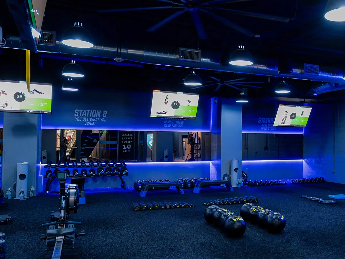 SWEAT440 virtual trainer screens guiding members through a station