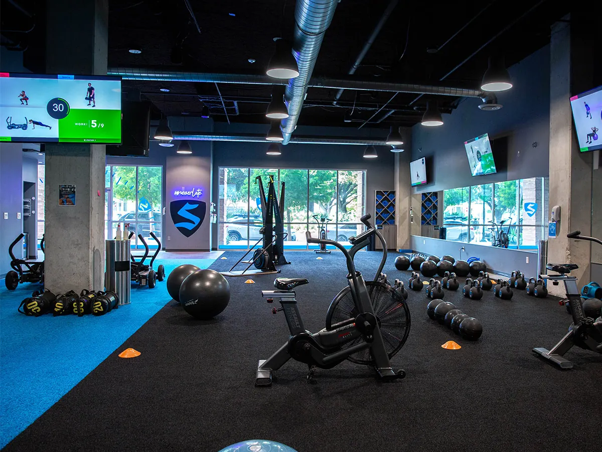 SWEAT440 studio floor with a time-efficient 4-station workout setup