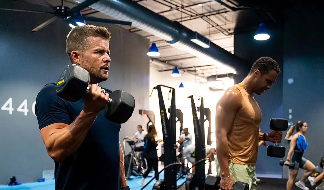SWEAT440 franchise member training with a dumbbell at the Brickell studio